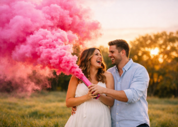 Casal celebrando revelação de sexo do bebê com fumaça rosa